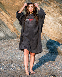 Woman stood on a beach with wet hair, wearing Slate Grey Organic Towel dryrobe®