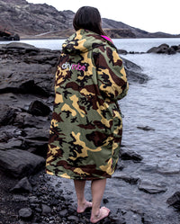 Woman stood on shoreline with back to the camera, wearing Camo Pink dryrobe® Advance Long Sleeve