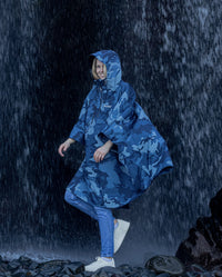 Woman walking infront of waterfall, wearing  Blue Camo dryrobe® Waterproof Poncho 
