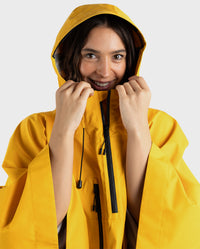 Close up of woman smiling wearing Yellow dryrobe® Waterproof Poncho with hood up