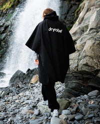 *MALE* walking towards waterfall wearing Black dryrobe® Waterproof Poncho 