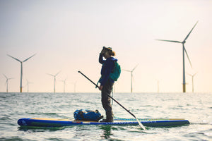 Stand Up Paddleboarding in front of a wind farm