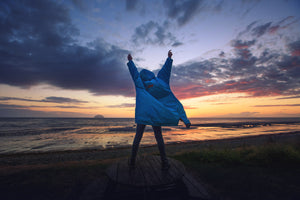 Woman with her hands up in the air wearing a Blue dryrobe Advance