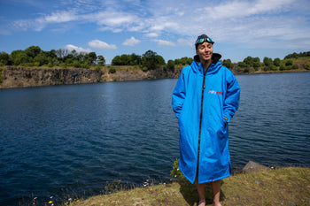 Joanna Shimwell stood next to a lake wearing a Cobalt Blue dryrobe Advance