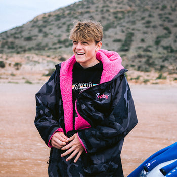 Lukas Skinner laughing on the beach before a comp in a dryrobe 