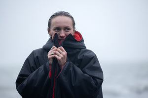 Woman wrapped in dryrobe Advance on the beach smiling 