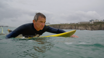 Pegleg paddling a surfboard during the English Adaptive Surf Open at The Wave in Bristol