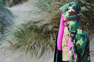 Child standing in sand dunes wearing a camo pink dryrobe® Advance change robe.
