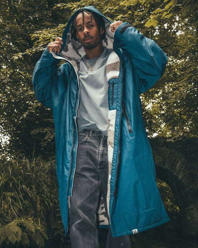 *MALE* standing next to bridge wearing AW25 Blue Dryrobe® advance long sleeve 