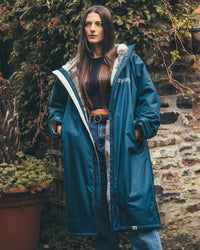 Woman outside in garden wearing AW25 Blue Dryrobe® advance long sleeve 