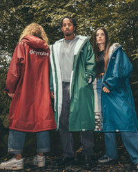 *MALE* and females Female standing by trees wearing AW25 Green, Blue and Burgundy Dryrobe® advance long sleeve's