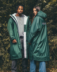 *MALE* and female standing by trees wearing AW25 Green Dryrobe® advance long sleeve 