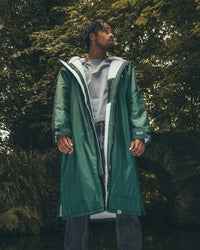 *MALE* standing by trees wearing AW25 Green Dryrobe® advance long sleeve 
