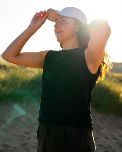 Woman on beach wearing grey Dryrobe® water resistant cap 
