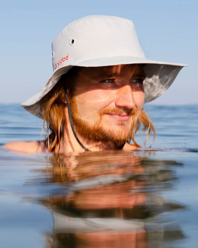 Male in water wearing grey Dryrobe® water resistant wide brimmed hat 