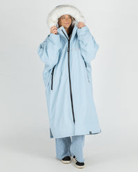 Woman wearing dryrobe Advance Long Sleeve Alpine Range change robe  in Alpine Ice Blue, pulling hood up