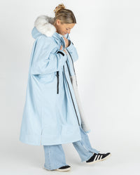 Woman stepping to the side, wearing dryrobe Advance Long Sleeve Alpine Range change robe in Alpine Ice Blue