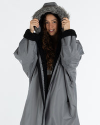 Woman wearing dryrobe Advance Long Sleeve Alpine Range change robe in Alpine Graphite with hood up 