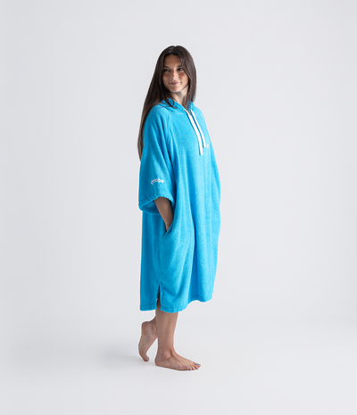 Woman wearing a blue towel robe with a brand logo on a white background