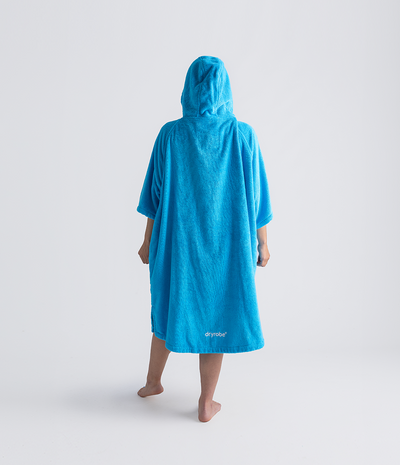 Person wearing a blue hooded towel robe on a white background