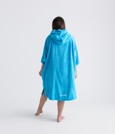 Person wearing a blue hooded towel robe with a brand logo on a white background