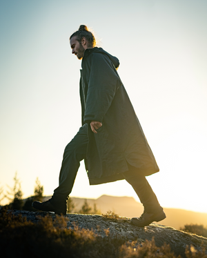 Man walking on a rocky outcrop with a scenic background