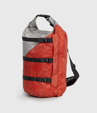A red and gray waterproof dry bag backpack with black straps and a black shoulder strap, shown on a light gray background.