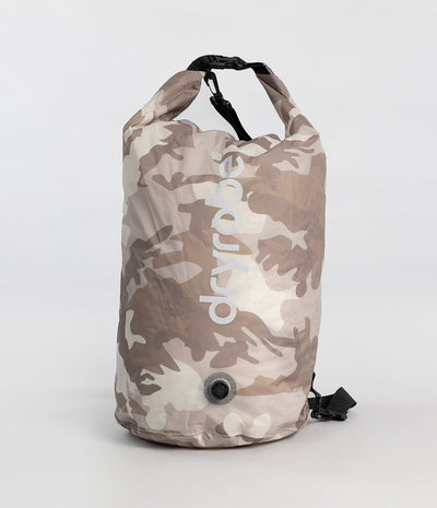 A Dryrobe waterproof compression bag. in a beige and brown camouflage pattern, featuring a vertical white 'dryrobe' logo and a black quick-release strap at the top, set against a plain light gray background.