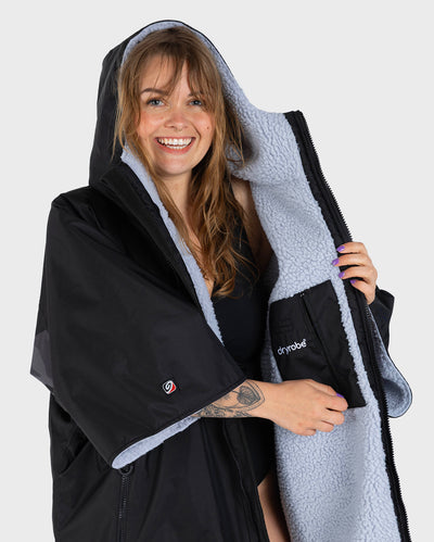 Adult female in studio wearing Dryrobe® black grey remix