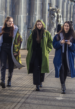 Three girls walking together down a street, wearing dryrobe® Advance Long Sleeve