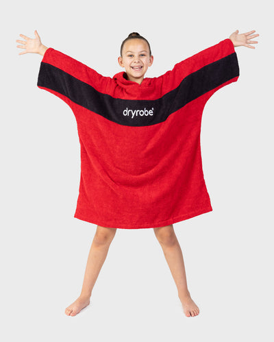 Child wearing Kids Organic Towel dryrobe - Remix in Red Black holding arms out 