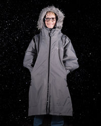 Boy stood in snow wearing dryrobe Advance Long Sleeve Alpine Range changing robe in Alpine Graphite with hood up 