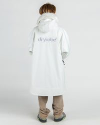 Boy with back to the camera, wearing dryrobe Advance Long Sleeve Alpine Range changing robe in Alpine White