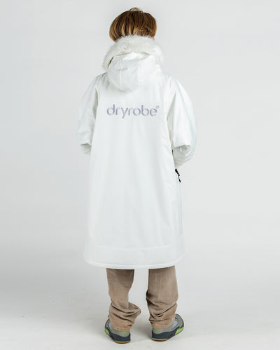Boy with back to the camera, wearing dryrobe Advance Long Sleeve Alpine Range changing robe in Alpine White