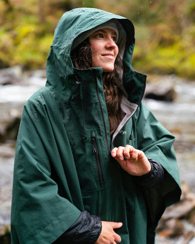 female wearing Dryrobe® green poncho in front of river