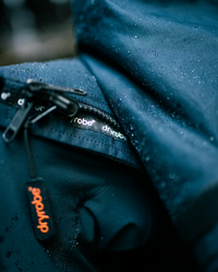 Close-up of a blue jacket with 'dryrobe' branding on a blurred background
