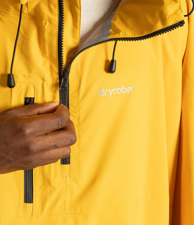 *MALE* Close-up of a yellow Dryrobe jacket with a hand adjusting the front zipper, showing the white 'dryrobe' logo on the chest.