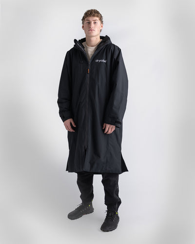 *MALE* Person wearing a long black Dryrobe Nexus on a white background