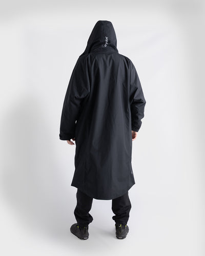 *MALE* A person shown from the back wearing a black Nexus, black pants, and black shoes against a plain light grey studio background.