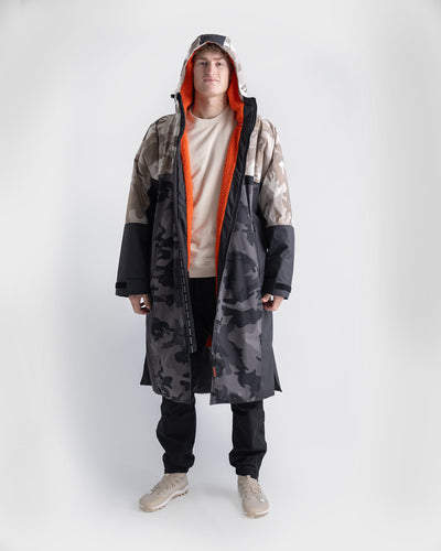 *MALE* Person wearing a long, patterned Dryrobe Nexus with a hood on a white background