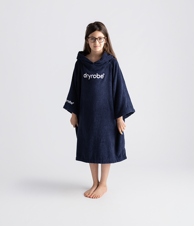 Child wearing a navy blue dryrobe on a white background