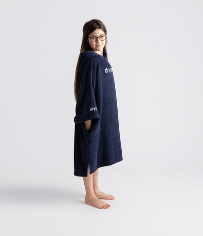 Person wearing a navy blue hooded towel robe with 'dryrobe' branding on a white background