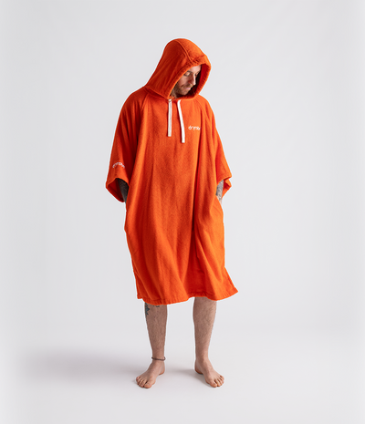 *MALE* Person wearing an orange hooded poncho on a white background