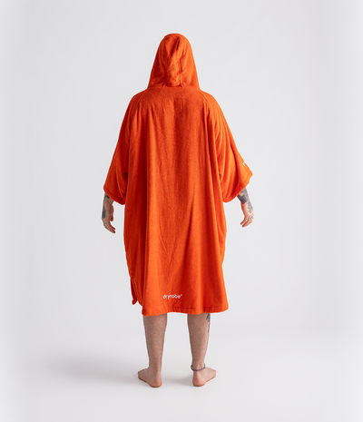 *MALE* Person wearing an orange hooded towel robe on a white background