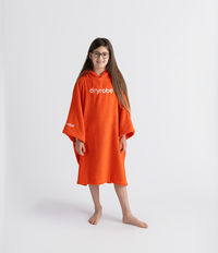 Person wearing an orange dryrobe towel robe on a white background