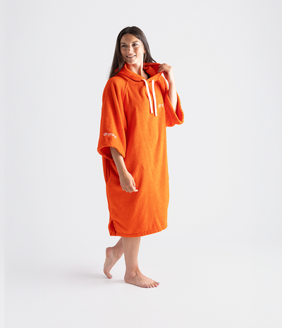 Woman wearing an orange hooded towel robe on a white background