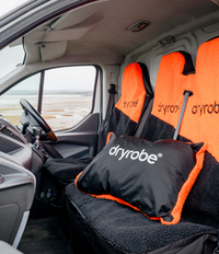 Dryrobe® seat covers on a vehicle interior with a scenic view outside.