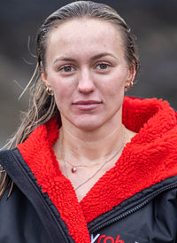 Close up of young woman stood in the rain, wearing Black Red dryrobe® Advance