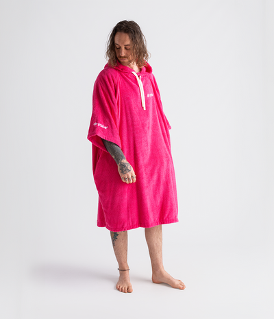 *MALE* Person wearing a bright pink hooded towel robe on a white background