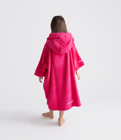 Person wearing a bright pink hooded towel robe on a white background